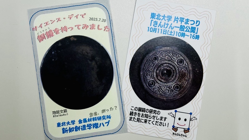 表面には「サイエンス・デイで銅鏡を持ってみました」、裏面には「東北大学片平まつり『きんけん一般公開』10月11日（土）10時～16時」と書かれている