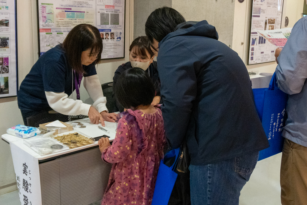 実験コーナーの受付のようす
母親に付き添われた小さな子どもが受け付けしている