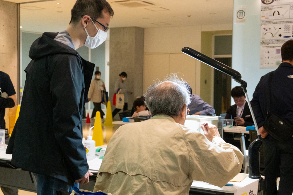 密度測定の実験をしている白髪の男性