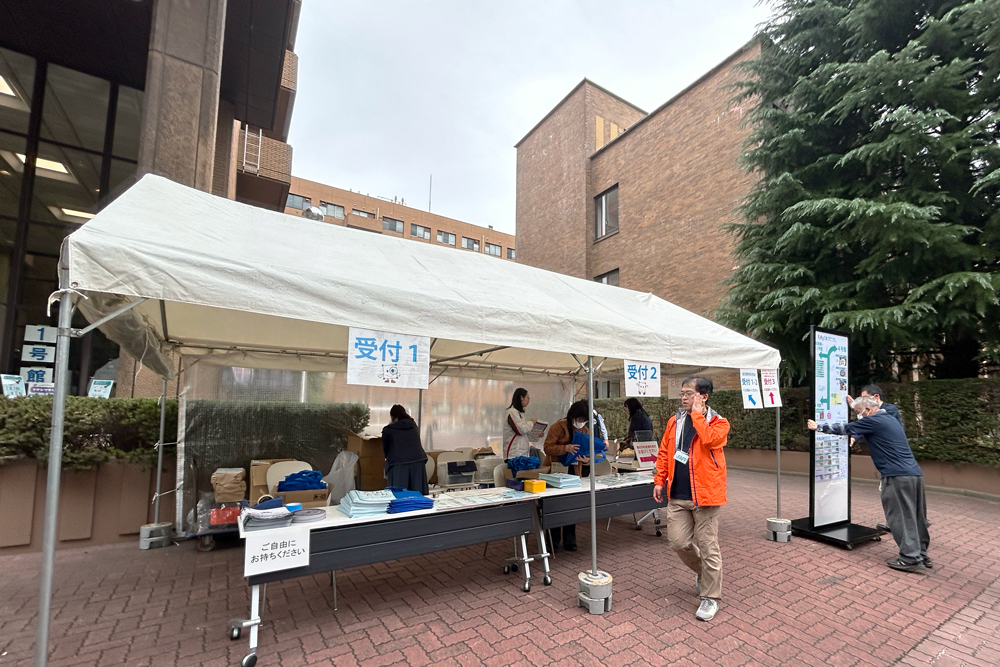 研究所のキャンパス内にテントが張られ、イベント受付の準備をしているようす