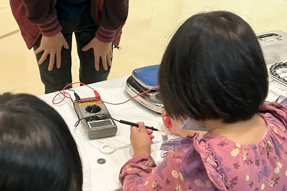 テスターの使い方を教えてもらい、試している子ども