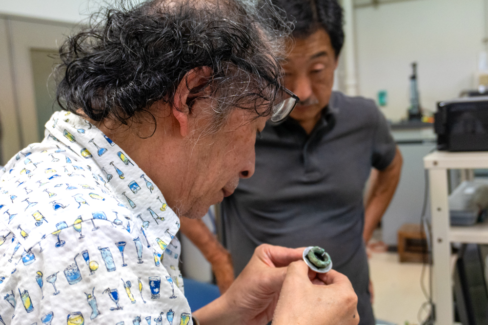 遺物観察の準備のため取り付け状態を確認している男性