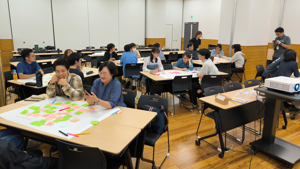 数人ずつ分かれてテーブルを囲み、話し合う人たち