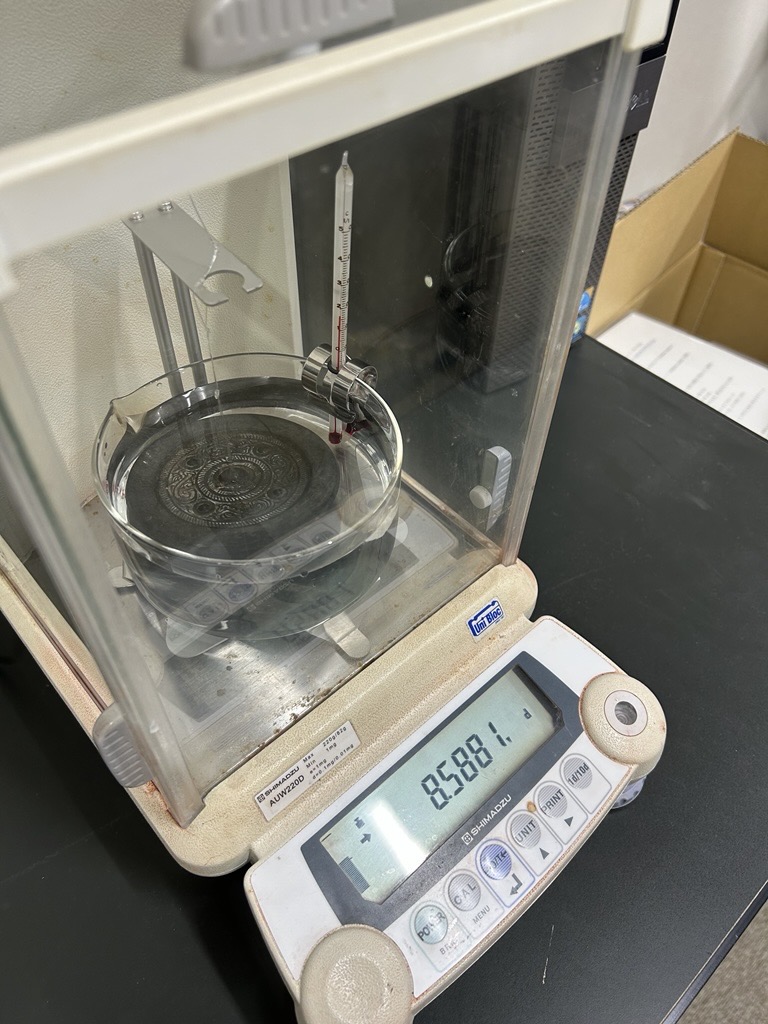 電子天秤内の水槽に浸かっている銅鏡