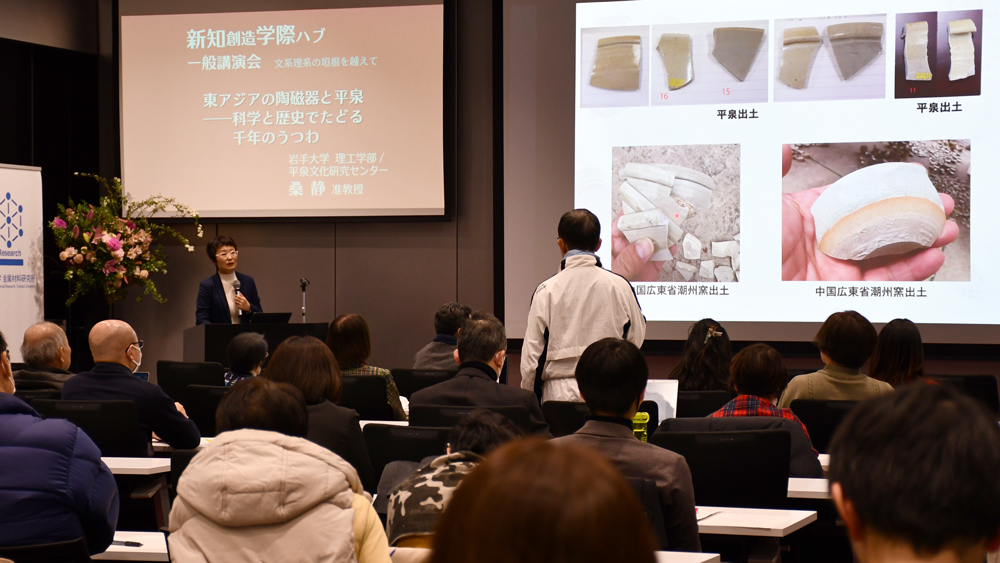 立ち上がって登壇者に質問する男性