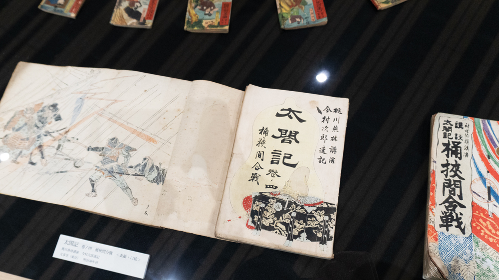 和紙に「太閤記」「桶狭間合戦」と縦書きされた本が展示されているようす
