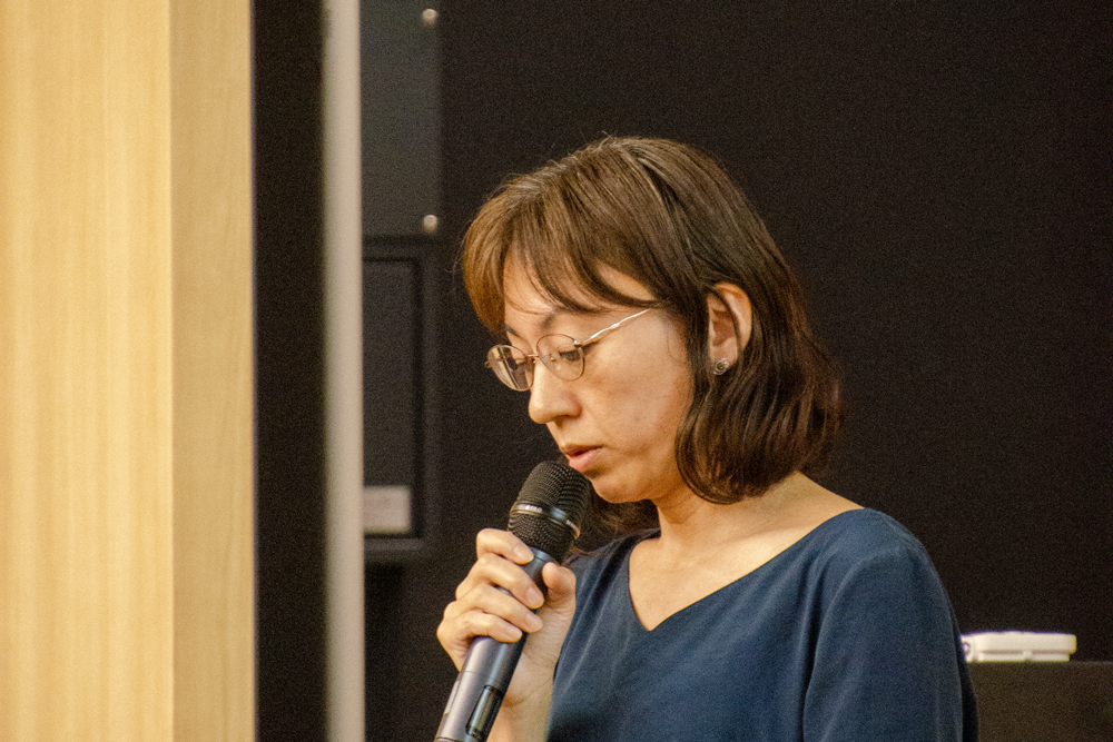 マイクを持って話している女性