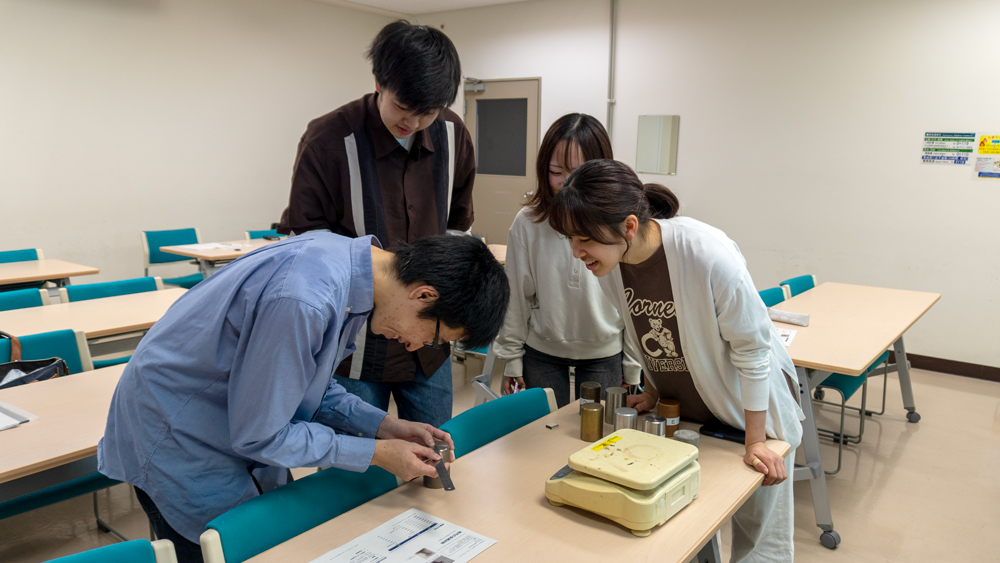定規で長さを測る男性とそれを覗き込む女性
